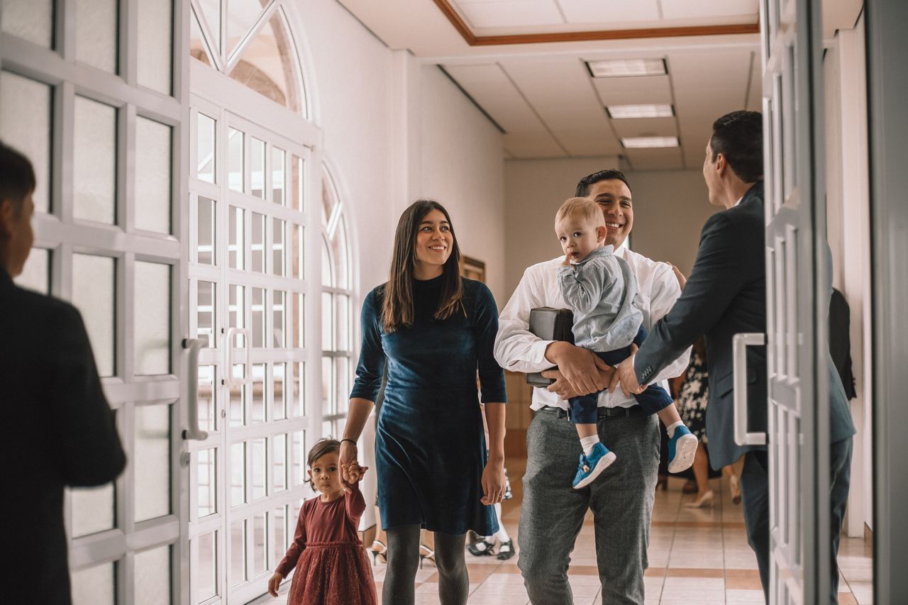 Mladá rodina přichází do církevní budovy, aby se učila o evangeliu Ježíše Krista